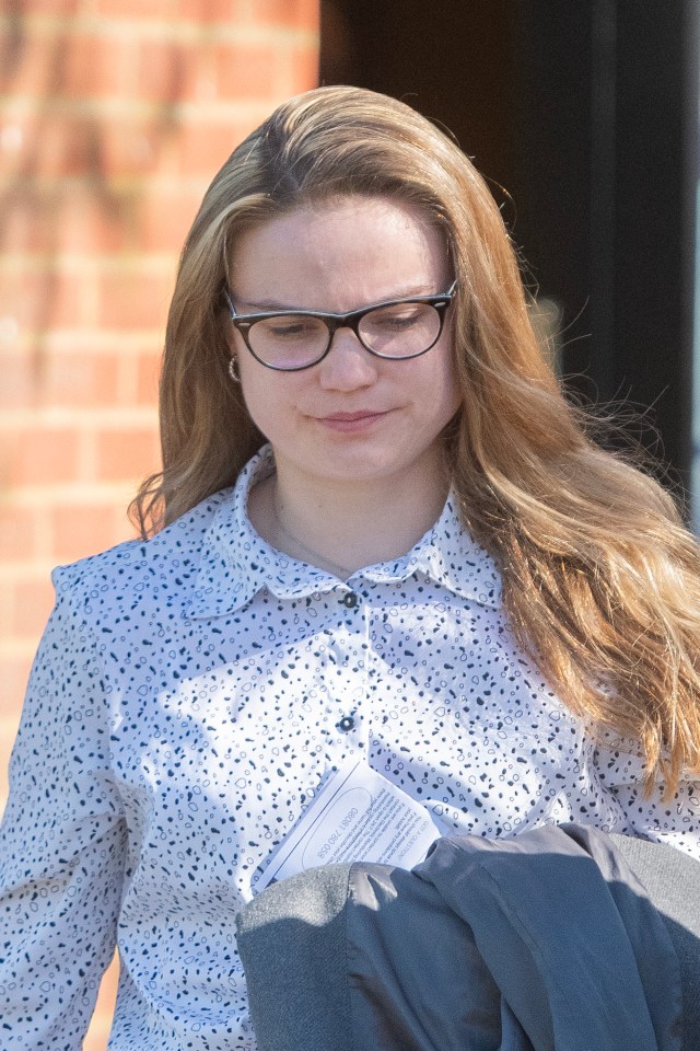 A policewoman in glasses looks down.