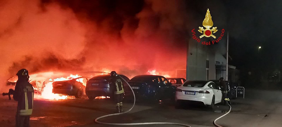 Firefighters extinguishing a fire at a Tesla dealership.