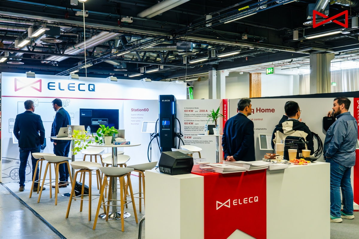 ELECQ employee discussing smart EV charging solutions with a client at exhibition.