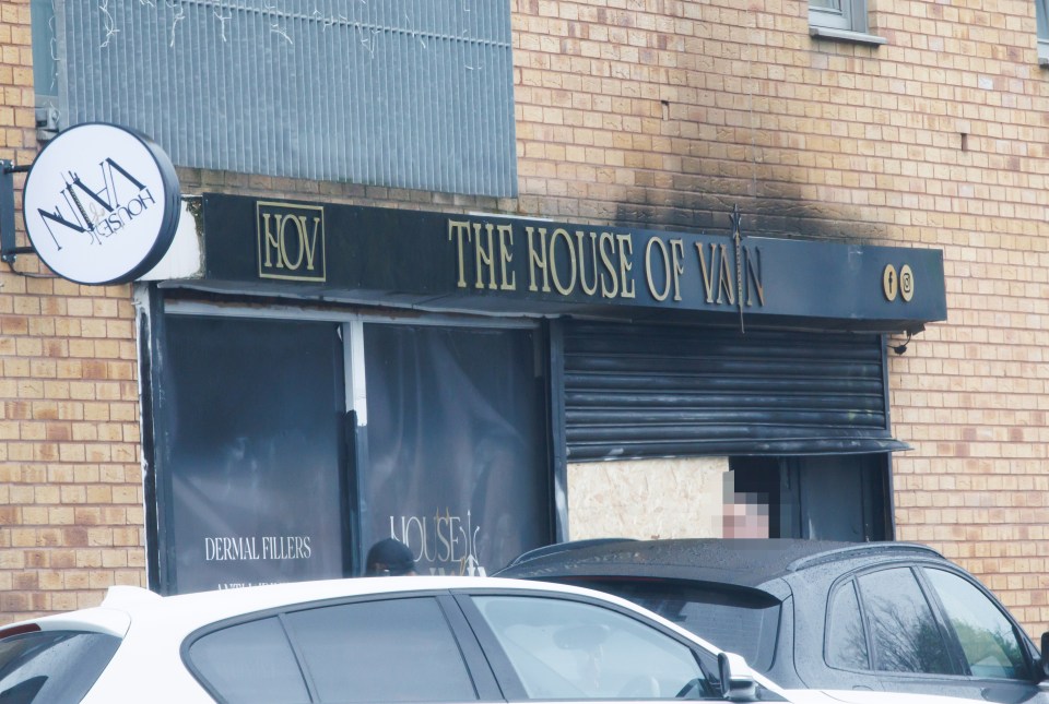 Fire-damaged hair salon boarded up.