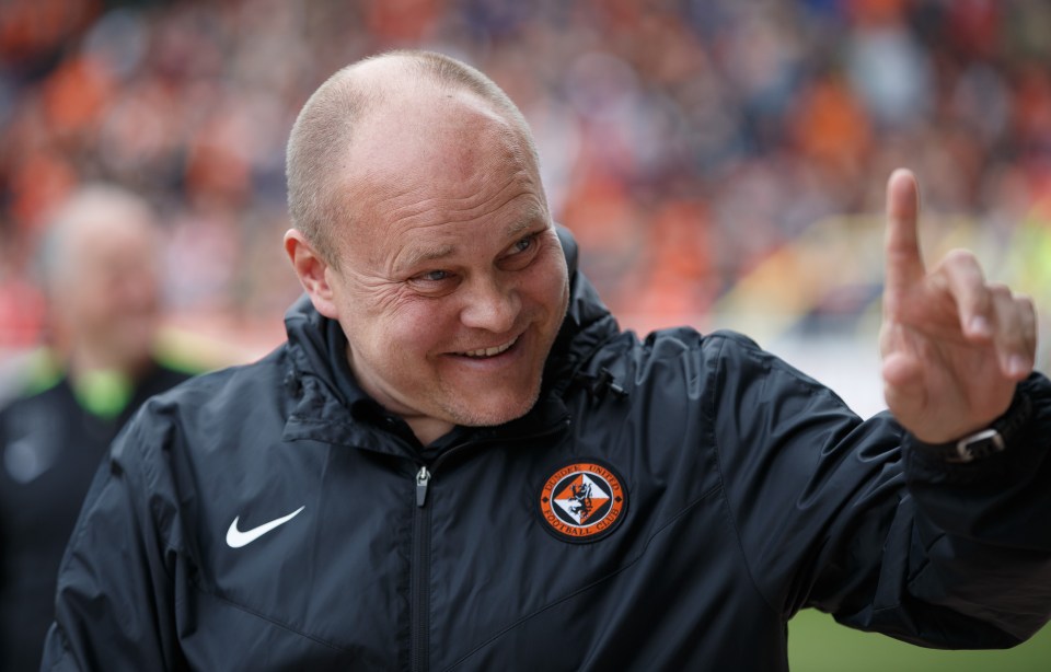 A man in a Dundee United jacket gestures with his index finger raised.