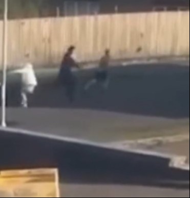 Three people fighting in a street brawl.