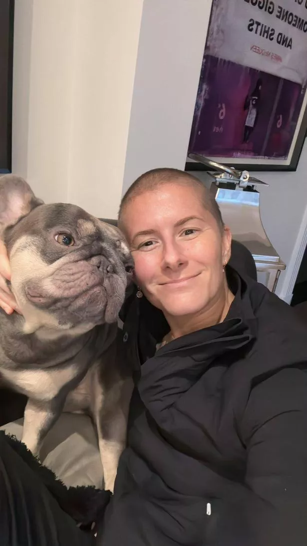 Olivia in a black jumper with her grey and white French Bulldog