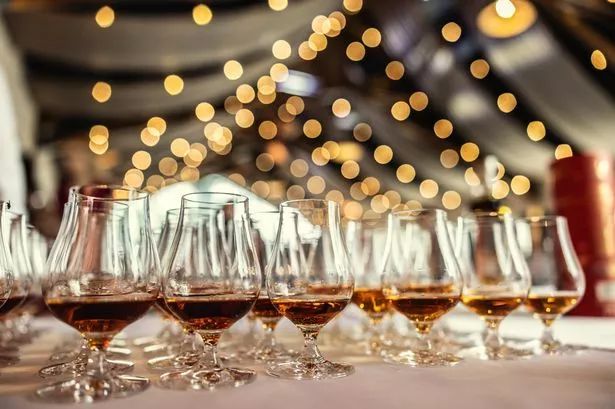 Many glasses with rum, brandy, cognac or whiskey on the bar counter prepared for guests as a welcome drink.