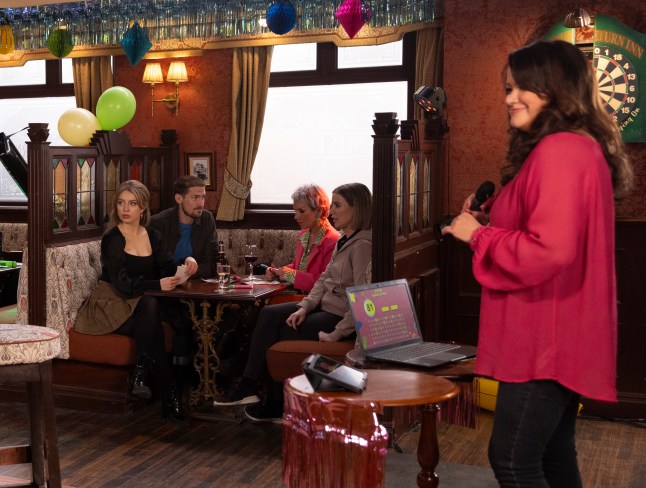 Christina speaks to a room full of people in the pub in Corrie