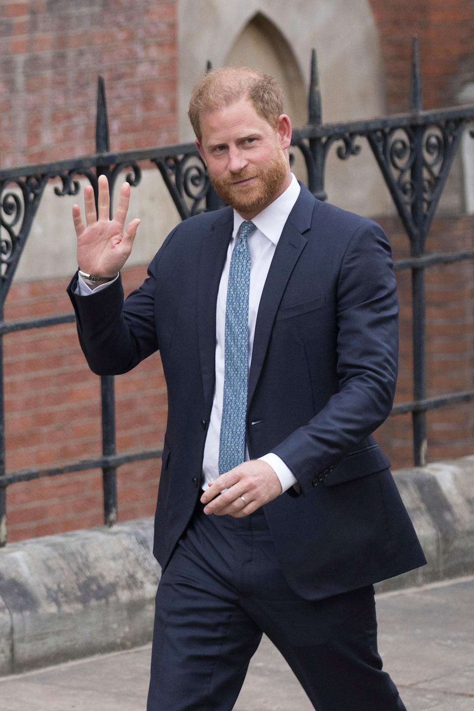 Prince Harry wearing a blue suit and waving outside court on April 8, 2025
