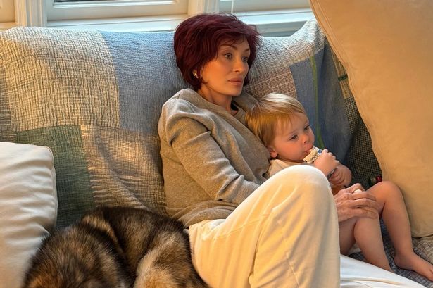 Sharon Osbourne sat with bare-feet on a sofa 