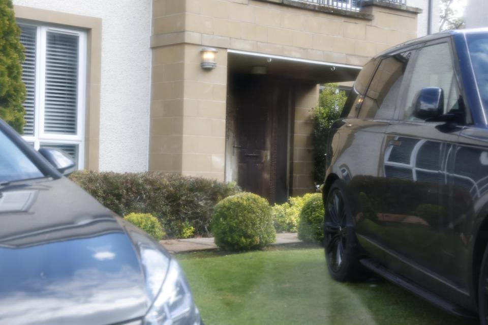 Dark-colored SUV parked outside a house.