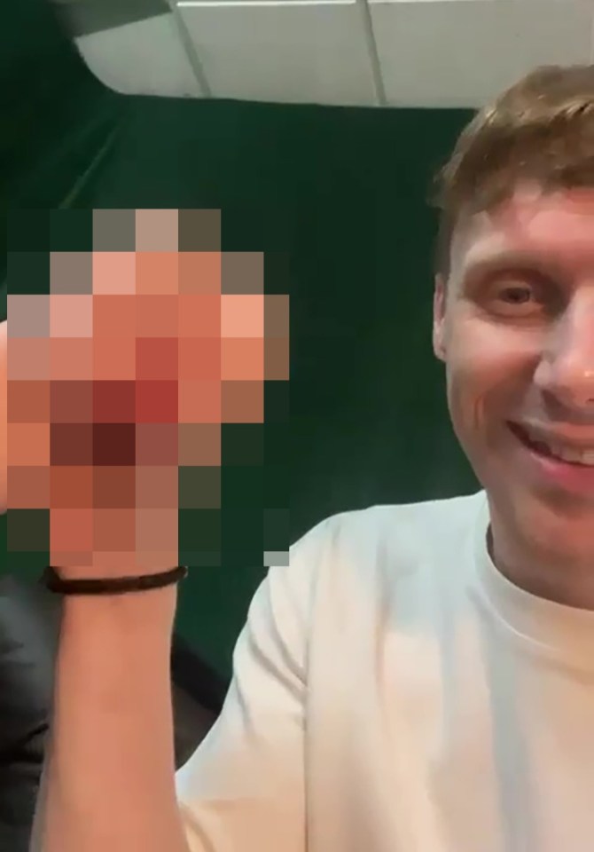 A pixilated image of a sex toy held by a man.