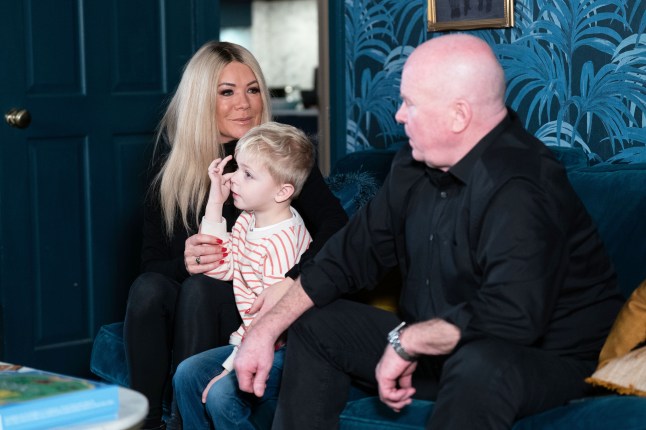 Sharon and Phil talk whilst Albie sits between them in EastEnders
