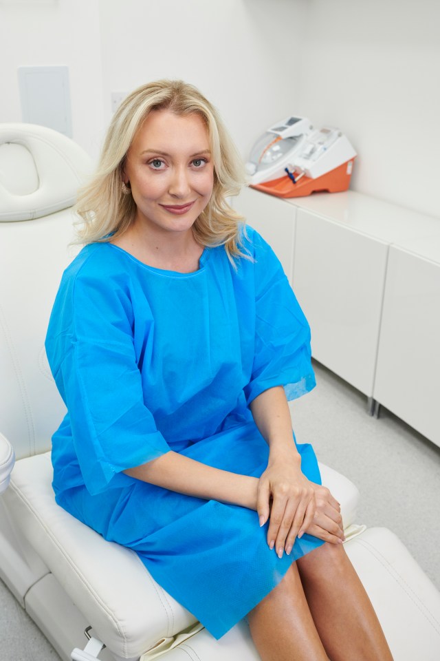 Woman in blue medical gown sitting on an examination table.