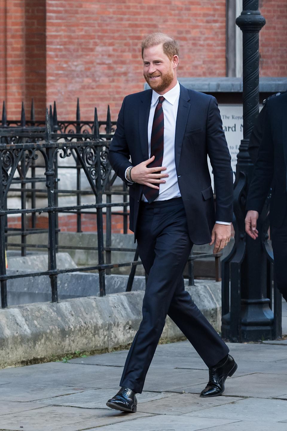 Prince Harry wearing a navy suit walking outside court in London on April 9, 2025