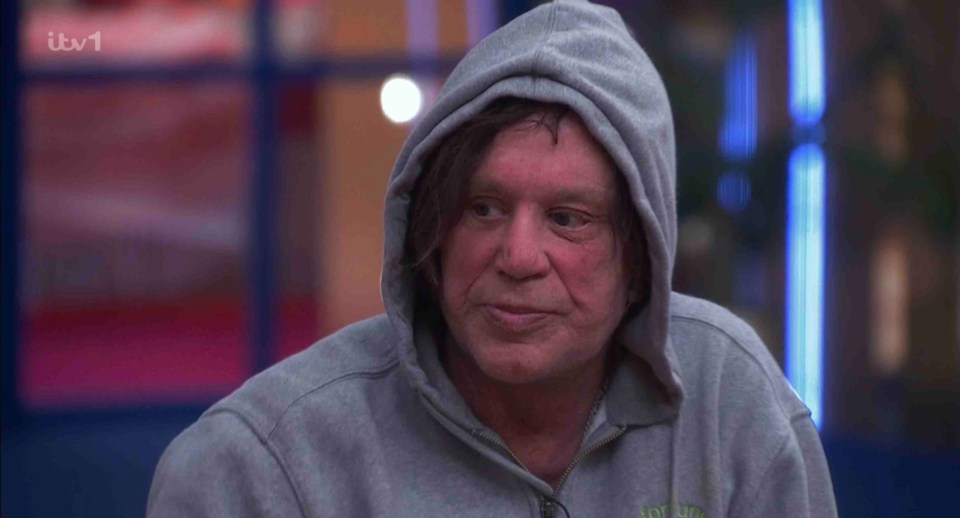 Mickey Rourke in a gray hoodie.