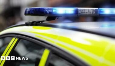 The top of a police car which has flashing blue emergency lights.