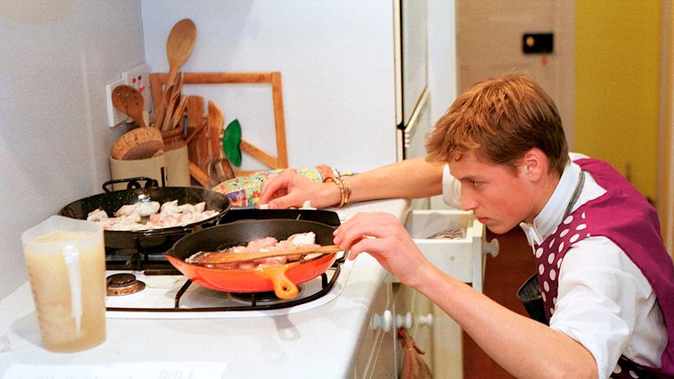 A young Prince William cooking in a school uniform.