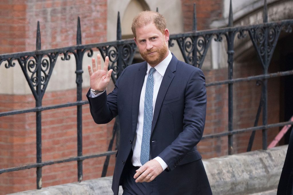 Prince Harry waves as he leaves court