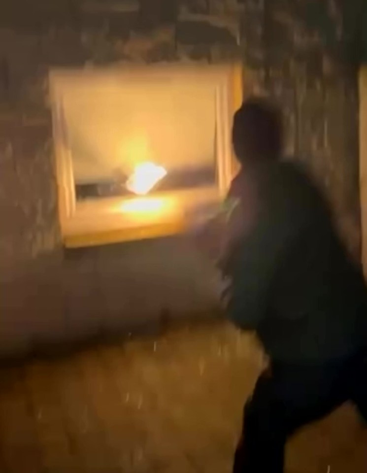 Person throwing flaming object through window.