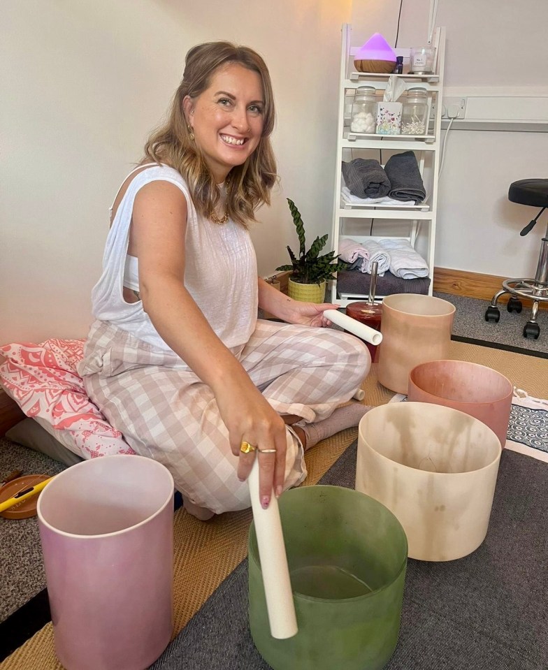 Woman sitting and playing singing bowls.