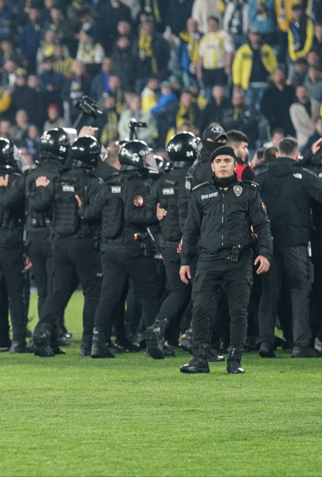 Soccer player doing a handstand on the field, surrounded by police.