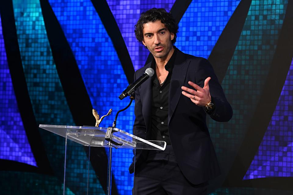 Justin Baldoni speaking at a podium