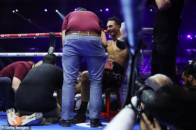 Whittaker pictured receiveing medical treatment after falling out of the ring in Saudi Arabia