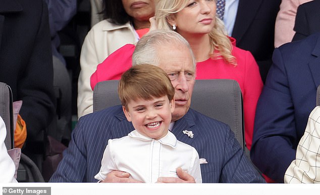 Louis appeared elated to sit on Charles's lap during the Platinum Pageant and beamed as his grandfather rocked him from side to side