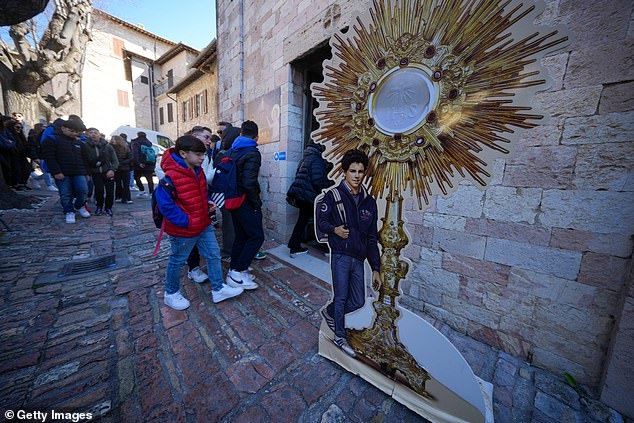 Pilgrims queue to enter the Church of Santa Maria Maggiore church and to pay their respects at the tomb of the Blessed Carlo Acutis