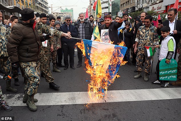 Iranians burn an Israel flag during a rally marking Al Quds Day in Tehran on March 28, in solidarity with Palestinians