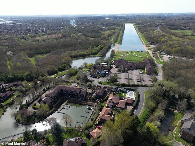 The Dragonfly Hotel (centre), with a bathing pool to the left of centre and houses and boat moorings below