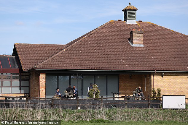 People are seen outside The Dragonfly Hotel in Thorpe Meadows, Peterborough, which is now being used to house asylum seekers
