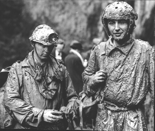 Mud-covered rescuers John Needham and Geoffrey Sutton at Peak Cavern in Castleton, Derbyshire