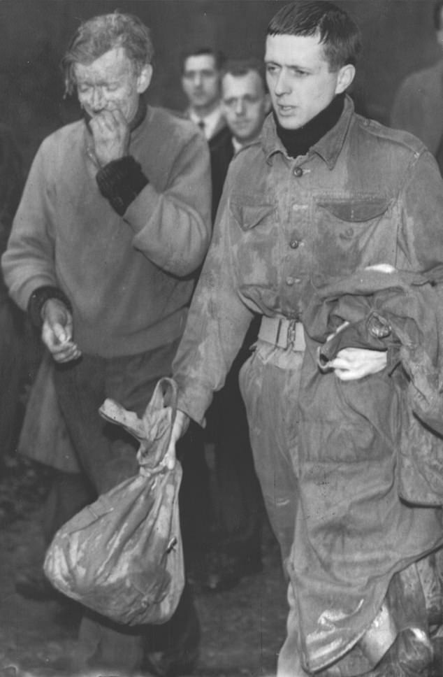 Flight Lieutenant John Carter (right) and a tearful fellow rescuer seen after spending hours trying to free Neil Moss