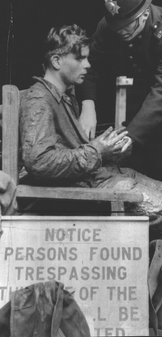 A policeman tends to rescue worker Michael Walker during the operation to free Neil Moss