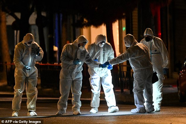 Greek Police experts search for evidences after a bomb explosion outside the Athens offices of Hellenic Train in Athens on Friday night