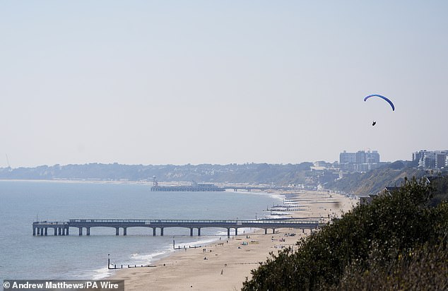 A person paraglides over the cliffs above Boscombe beach in Dorset, in spring sunshine. Picture date: Thursday April 10, 2025