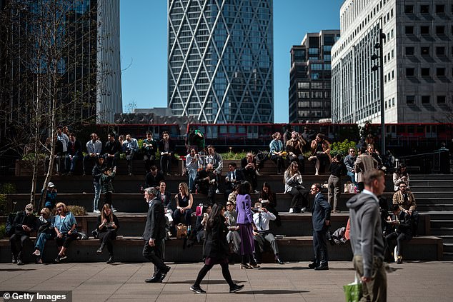 People enjoy their lunch in the sunshine in London's Canary Wharf business district on April 7, 2025 in London, England