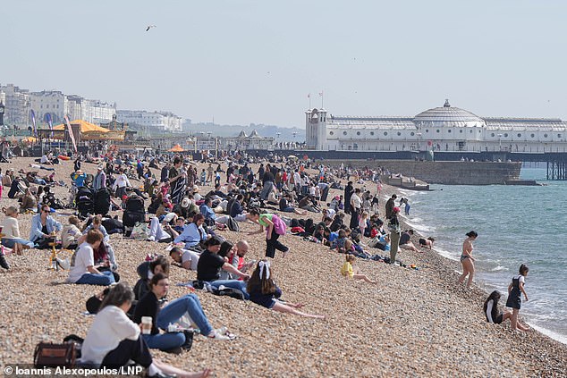 Members of the public enjoy a warm day on Brighton Beach. Spring sunshine and warm temperatures are expected to continue this weekend