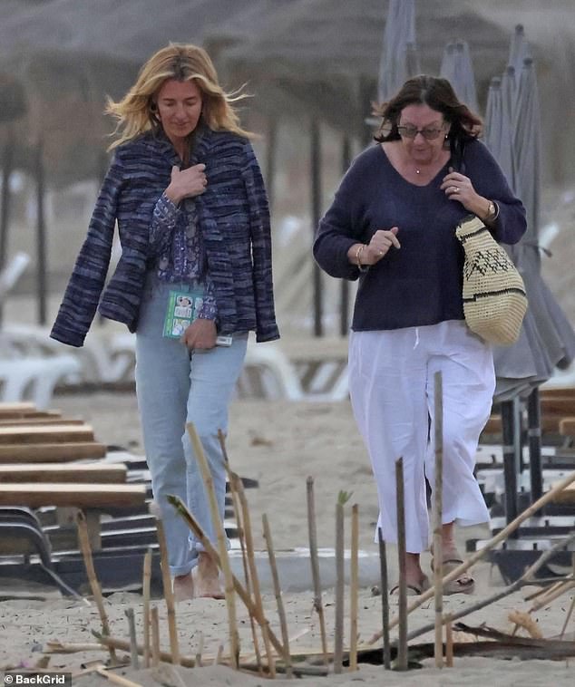 The This Morning presenter, 48, who is currently enjoying a break from her hosting duties, draped a blue striped jacket over her shoulders as she strolled along the beach with her mother