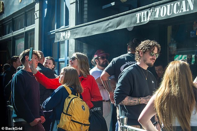 Two women were seen sneaking a selfie of the celebrity outside a pub in Soho