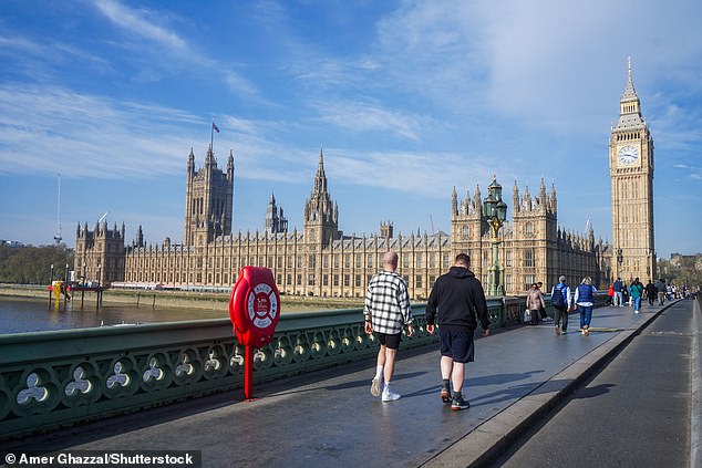 People are seen enjoying the sunshine on Westminster Bridge today