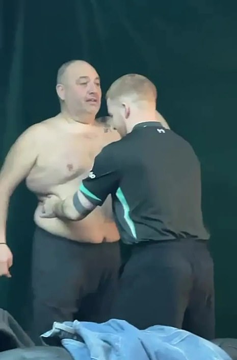 The actor smiles as he holds up the rubber toy, then points the camera at Wynne who is seen shirtless as he practices with professional dancer Neil Jones
