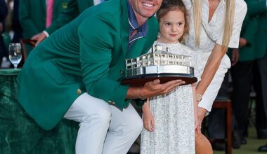 Rory McIlroy poses with daughter Poppy and wife Erica Stoll holding the Masters trophy during the Green Jacket Ceremony after winning the 2025 Masters Tournament at Augusta National Golf Club