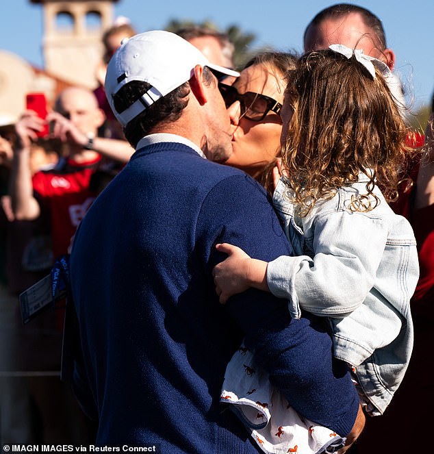 Rory kisses his wife Erica while holding his daughter Poppy after winning the Players Championship at TPC Sawgrass in March 2025