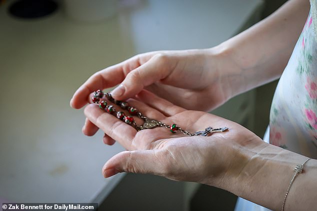 Maya holds her mother's rosary at the home she is preparing to leave. She has tried to channel Beata's drive as she takes the bold step to move across the country