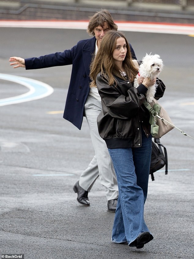 Ana wore a leather jacket and blue jeans while carrying her dog Elvis and walking her other pooch Salsa