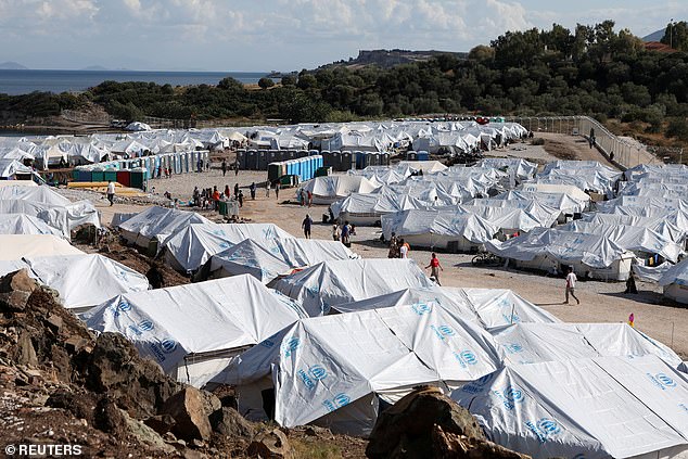 Refugees and migrants make their way in the Kara Tepe camp on the island of Lesbos, Greece