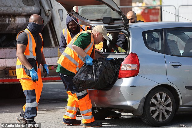 The workers, dressed in orange high vis, loaded the waste into the disposal lorries themselves