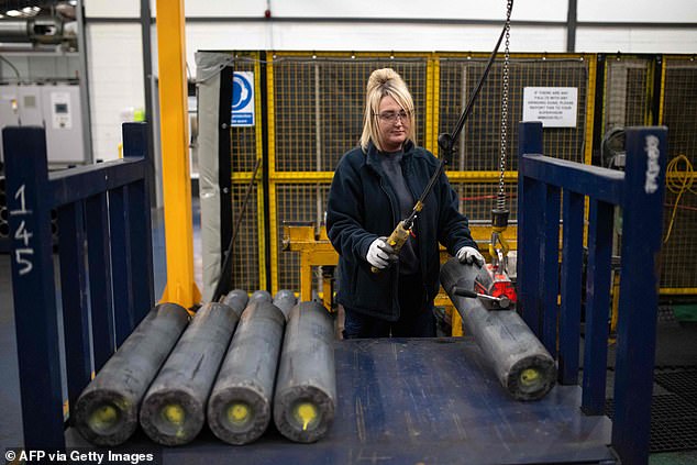 An employee manoeuvres 155mm artillery shell casings during their manufacturing process at the BAE Systems factory in Washington, near Newcastle upon Tyne in north-east England on November 8, 2023