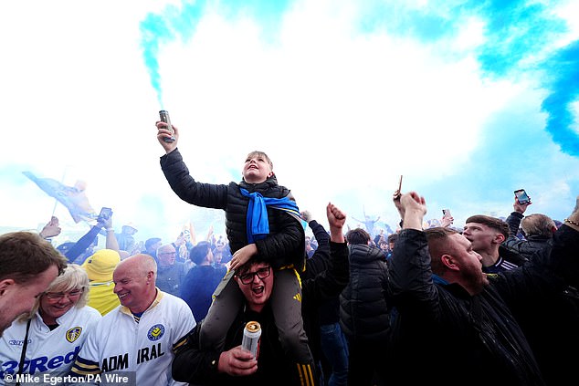 Leeds supporters jubilantly celebrate their club's promotion back to the Premier League