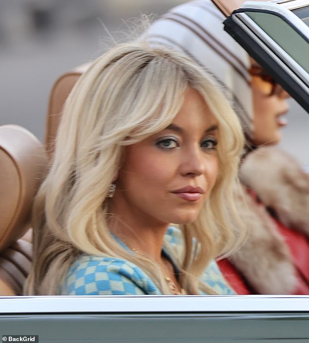 Swapping her signature skin-baring style for a more buttoned-up vibe, Sweeney sported a feathered hairstyle and a prim checked blouse, signaling big changes for her character.